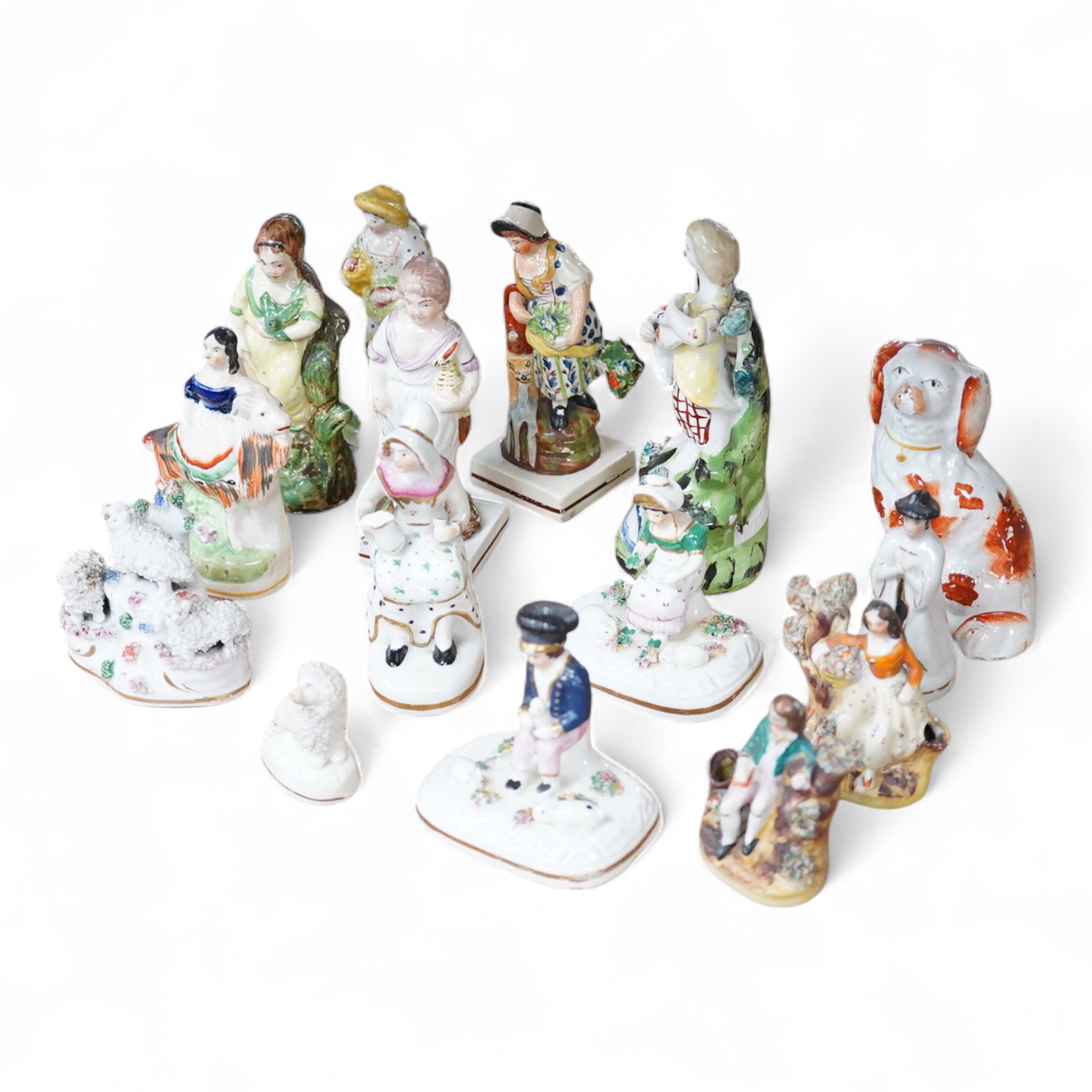 A collection of 19th century and later Staffordshire figures, mostly figural examples, including a pair a rare pair of porcelain seated figures with rabbits and a candle extinguisher, largest 15cm high (15)